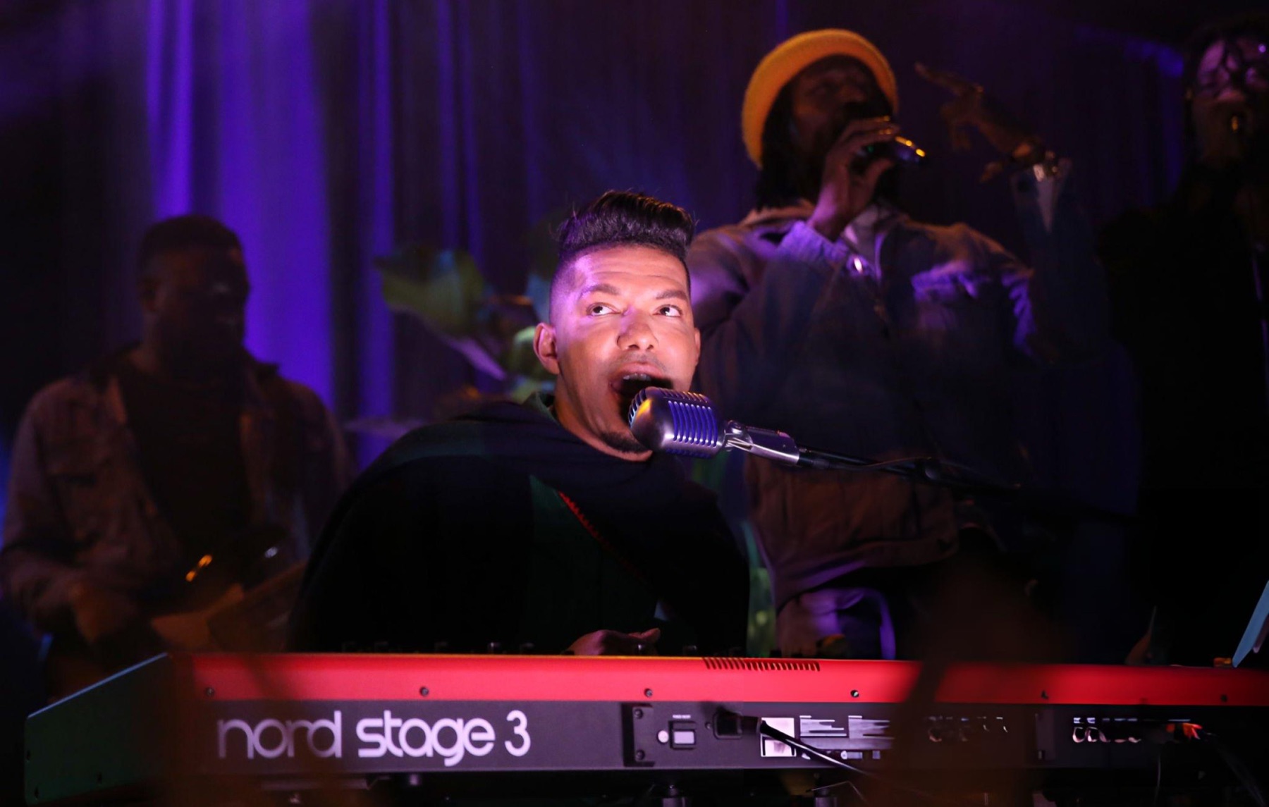 Stevie Mackey singing at the keys at the Marley Rose Music Festival